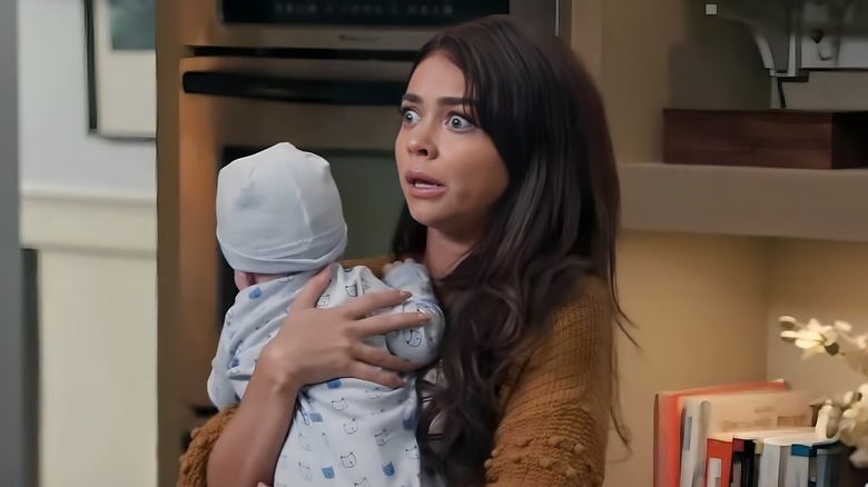 Haley Dunphy holding baby looking stressed