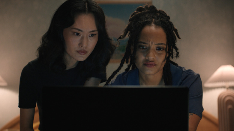 Keiko and May looking at a computer inside a hotel room in "Monarch"