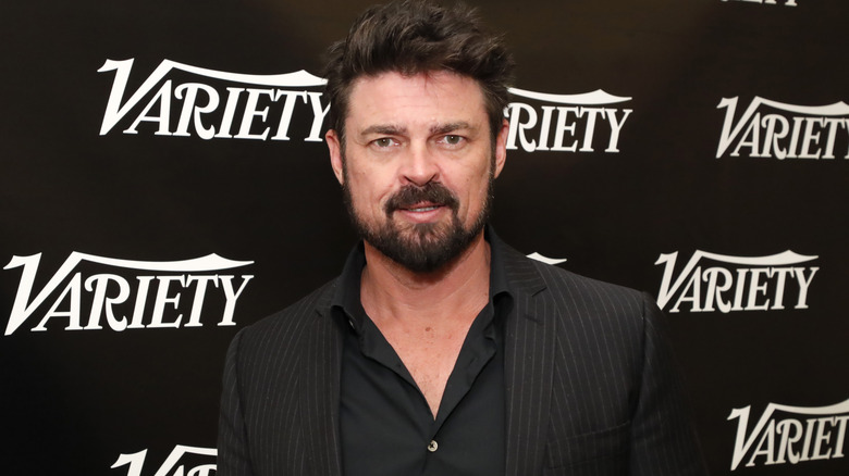 Karl Urban poses in front of a Variety backdrop