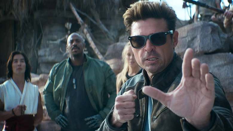 Johnny Cage in fighting stance in front of Liu Kang, Jax Briggs, and Sonya Blade in Mortal Kombat II (2026)