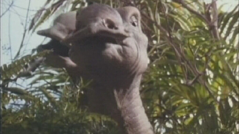 Dinosaur in front of tree