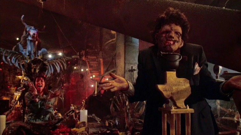 Leatherface giving off a shrug and displaying a trophy in "The Texas Chainsaw Massacre 2" (1986)