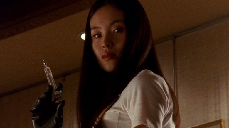 Asami looking down holding a needle in "Audition"