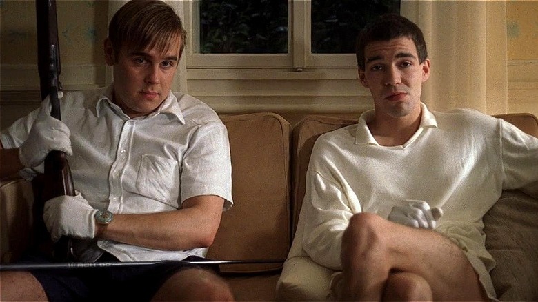Peter and Paul sitting on the couch with a gun in "Funny Games"