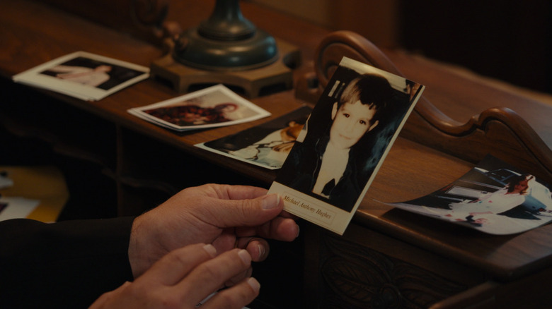 A hand holding an old photograph in The Girl in the Picture