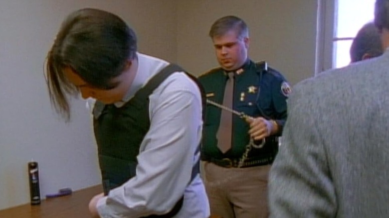 Police officer ready to chain up a man in Paradise Lost