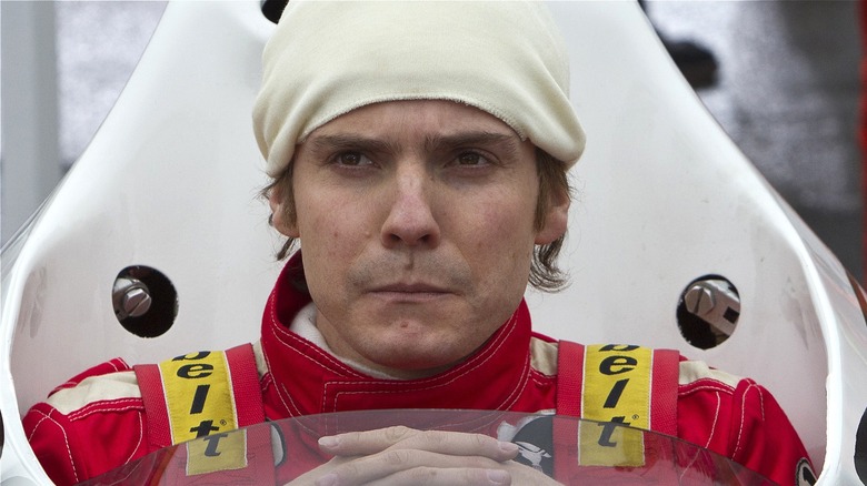 Lauda sitting in his car looking serious in Rush (2013)