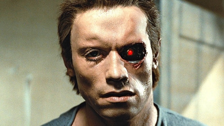 The T-800 looking at himself in the mirror with his red eye exposed in The Terminator