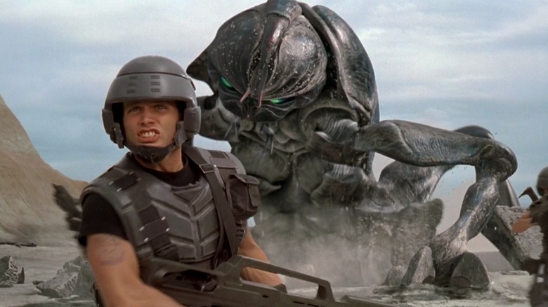 Johnny Rico running from a giant alien bug in Starship Troopers