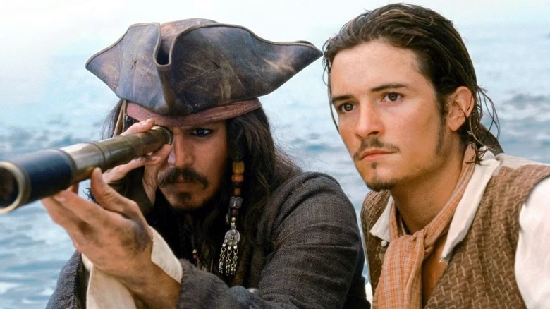 Jack looking through a telescope as Will stands beside him in "Pirates of the Caribbean: The Curse of the Black Pearl."