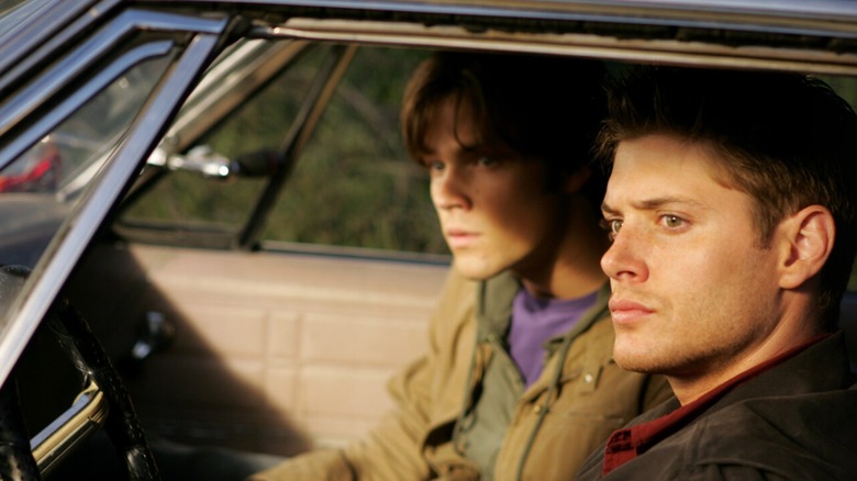 Sam and Dean inside of Baby looking at something off-screen in "Supernatural" (2005-2020)