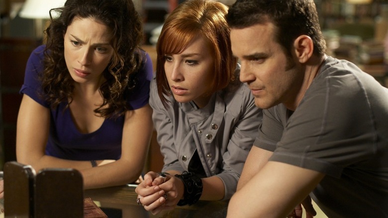 Myka, Claudia, and Pete looking at a Farnsworth in "Warehouse 13" (2009-2014)