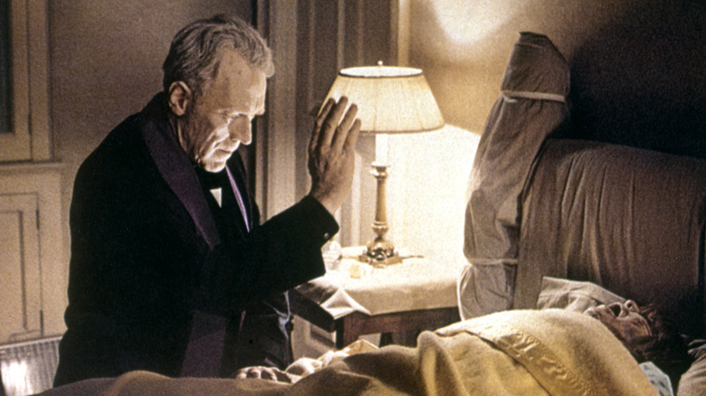 Father Merrin prays over Regan in "The Exorcist" (1973)