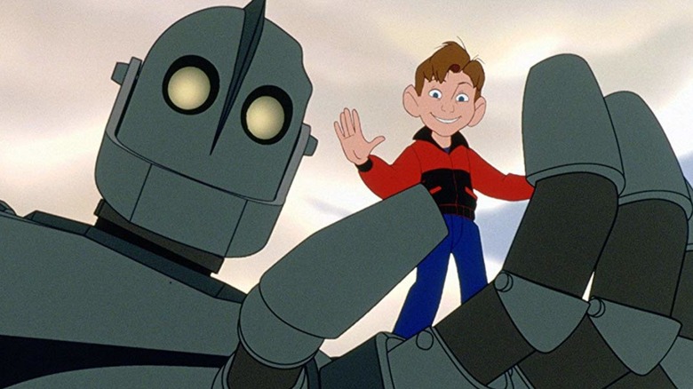 The Iron Giant holding up a waving Hogarth Hughes in "The Iron Giant"