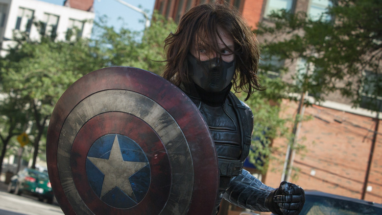 The Winter Soldier holding Captain American's shield in front of his super-powered arm