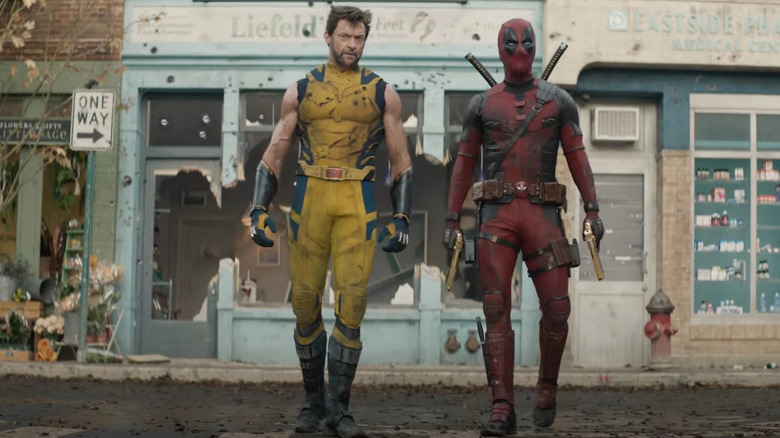 Wolverine and Deadpool walking away from a torn-up section of street