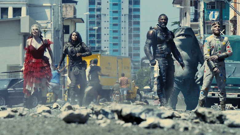 Harley Quinn, Ratcatcher 2, Bloodsport, King Shark, and Polka-Dot Man walking through destroyed city