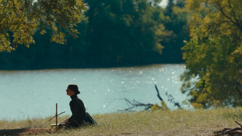 Claire sits beside a grave