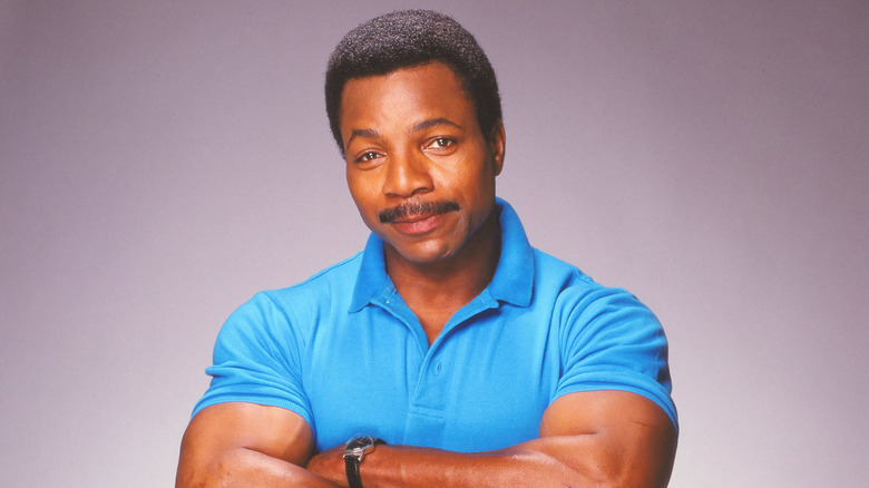 Carl Weathers with arms folded in a blue polo