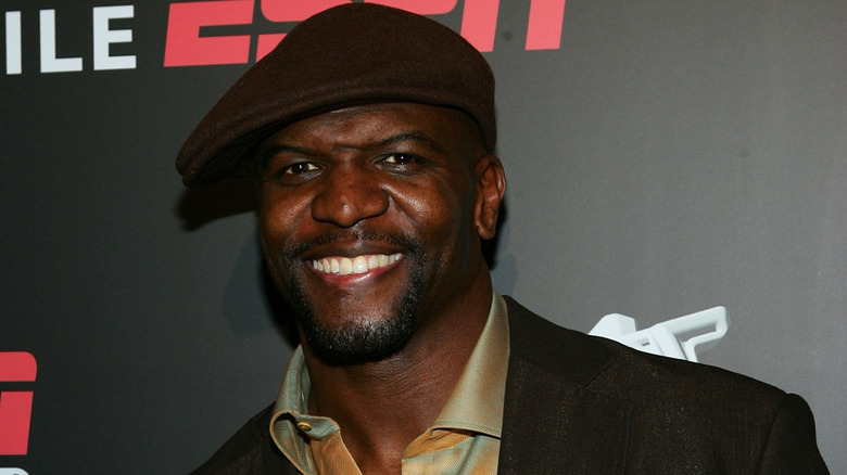 Terry Crews in a hat smiling at an ESPN event
