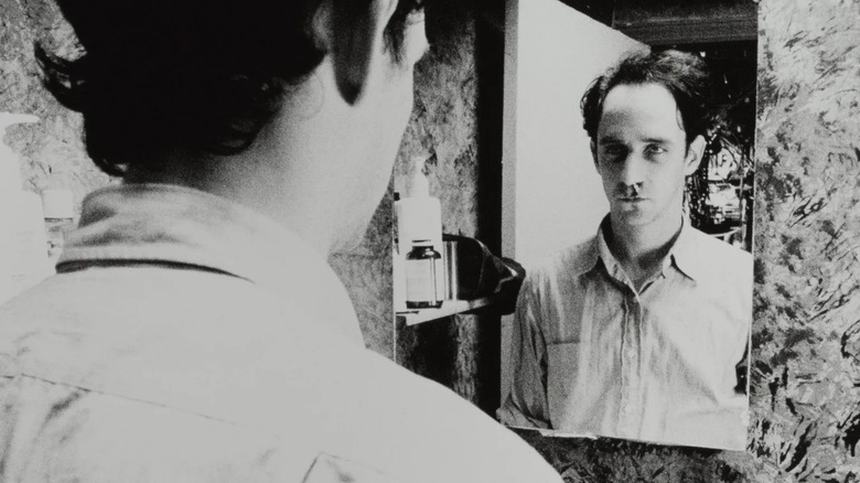 Max looking in bathroom mirror in "Pi" (1998)