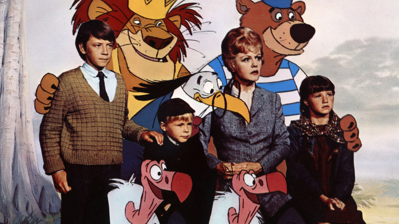 Miss Eglantine Price stands with children and animated animals in 'Bedknobs and Broomsticks' (1971)