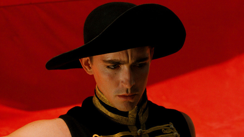 The Black Bandit stands in front of a red flag in 'The Fall' (2006)