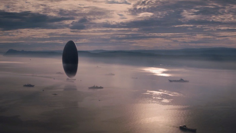 Oblong spacecraft hovering over ocean