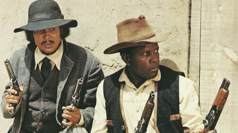 Buck and the Preacher each holding two guns