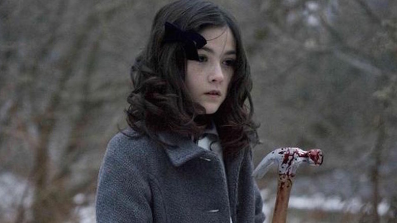 Leena/Esther holds a bloody hammer