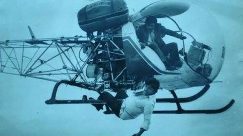 Jayan hangs from a helicopter