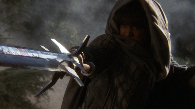 Talon holds three-bladed sword