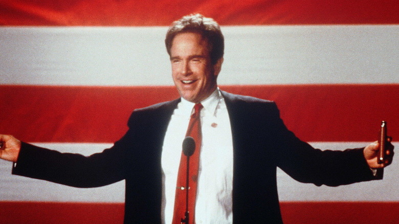 Senator Bulworth raises his hands in front of an American flag in "Bulworth" (1998)