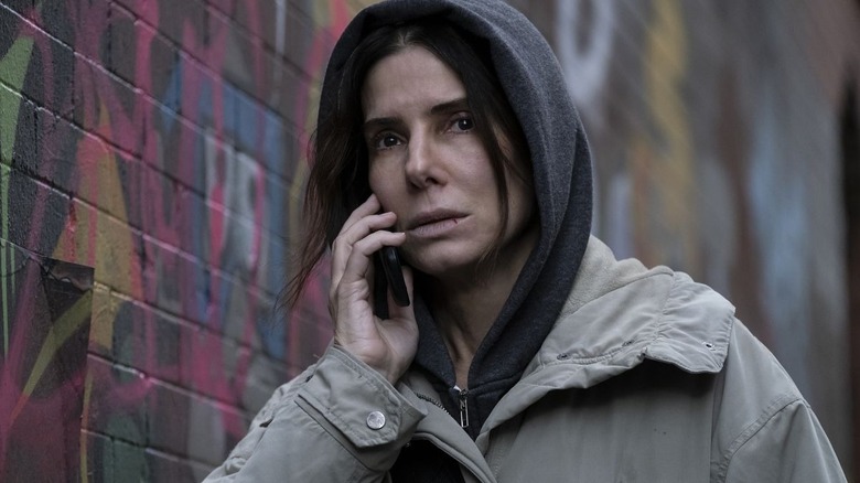 Ruth talks on the phone in an alley