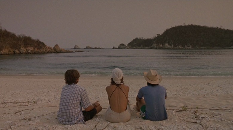 Diego Luna, Maribel Verdú, and García Bernal seated on beach from behind