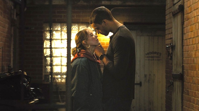 Ledger holding Kenna's chin as they stand close together in an alley in "Reminders of Him."