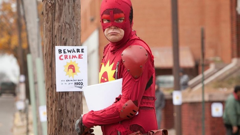 Crimson Bolt puts up flyers around the neighborhood in "Super" (2010)