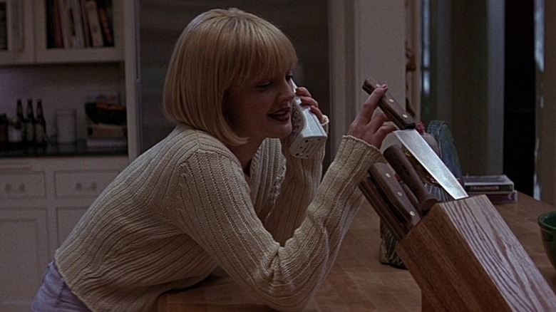 Casey Becker playing with a knife while talking on the phone (1996)