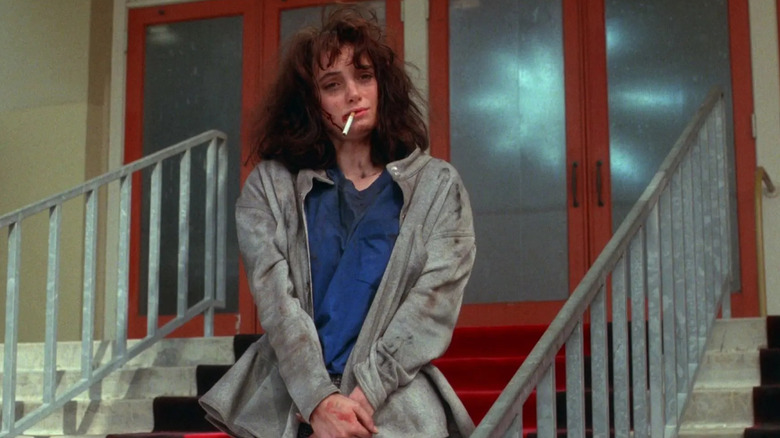 Dirty, bloody Veronica smokes a cigarette in "Heathers" (1988)