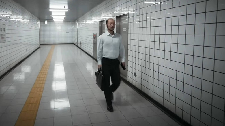 The Walking Man walks down a subway corridor in "Exit 8" (2025)