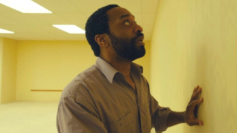Clark looking up as he pushes against a wall in 