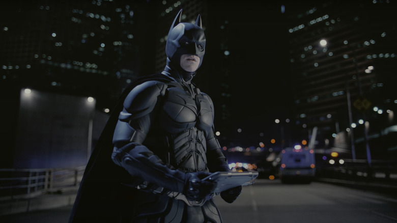 Batman standing on a road in his outfit in The Dark Knight Rises