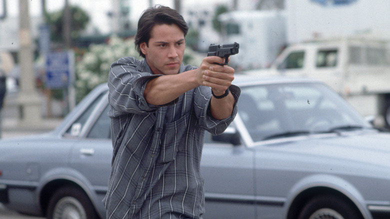 Johnny Utah aims a gun on the street in "Point Break" (1991)