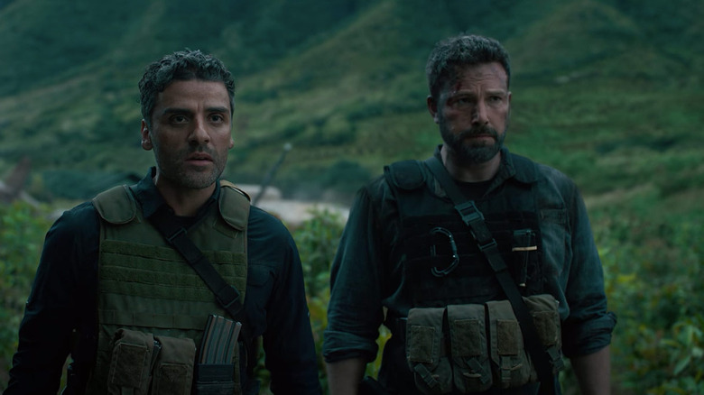 Tom and Santiago stand calmly in field gear in "Triple Frontier" (2019)