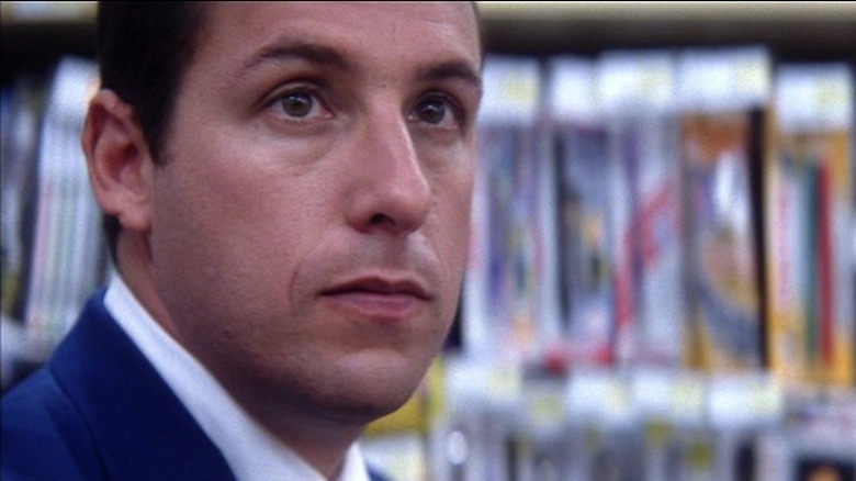 Adam Sandler in front of magazines