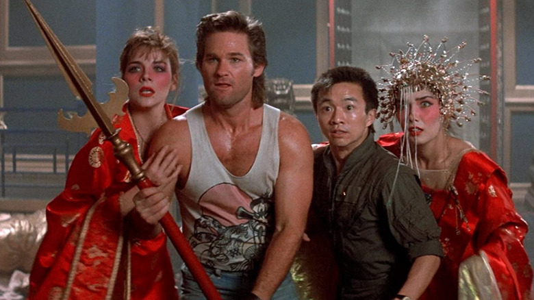 Jack Burton holds a spear as Wang Chi protects Gracie Law and Miao Yin, both wearing ornamental red dresses in "Big Trouble in Little China"