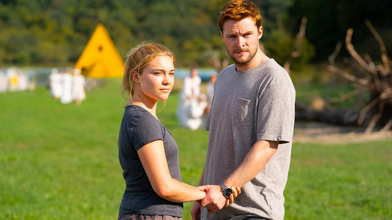 Dani and Christian holding hands and looking at something in Midsommar