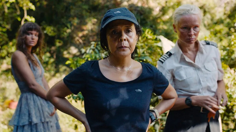 Abigail with her hands on her hips in front of Yaya and Paula in Triangle of Sadness