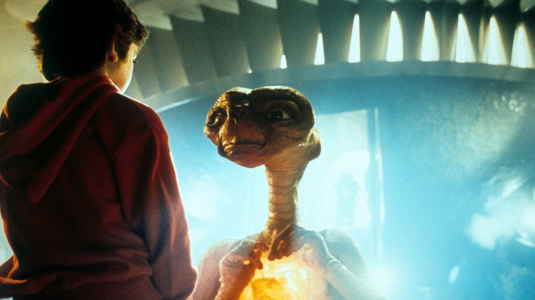 E.T. standing in front of his spaceship facing Elliott in E.T. the Extra-Terrestrial (1982)