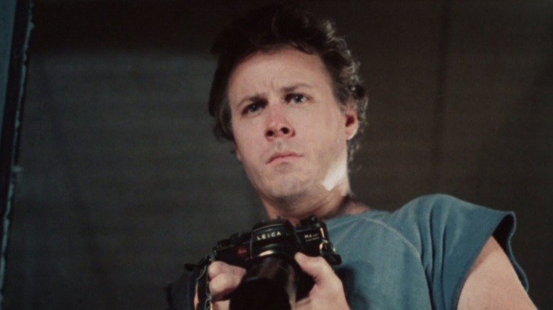 John Heard holding camera